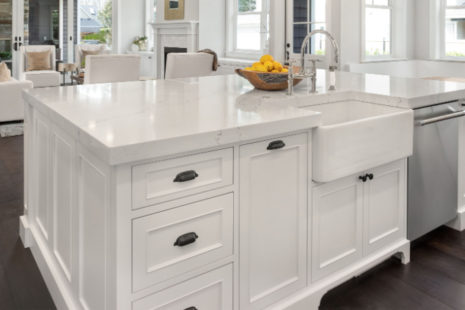 What holds a farmhouse sink in place?